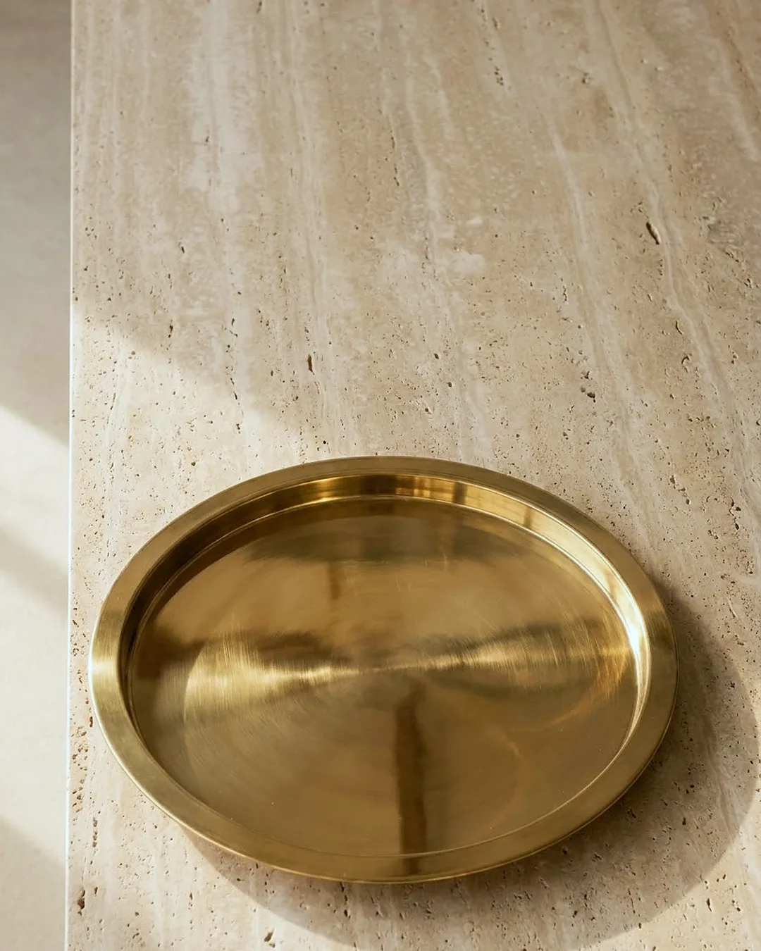 An empty brass tray on travertine